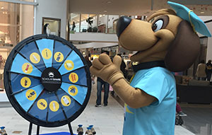 Scholarshare mascot spinning a prize wheel