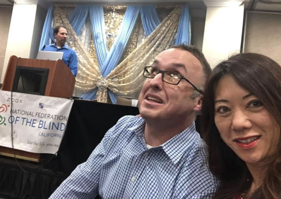 At the 2019 National Federation of the Blind California Convention with my friend Jonathan Lyens moments before speaking about serving as State Treasurer and the benefits of the California Achieving a Better Life Experience (CalABLE) program, whose board I chair. At the lectern is National Federation of the Blind of California President Tim Elder.