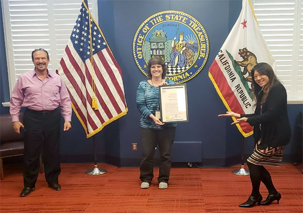 Centralized Treasury and Securities Management Division (CTSMD) Director Mark Hariri and Treasurer Fiona Ma practice social distancing while congratulating Anne Peery